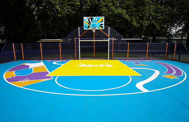 The finished court in blue, yellow and purple street art design, viewed from the baseline