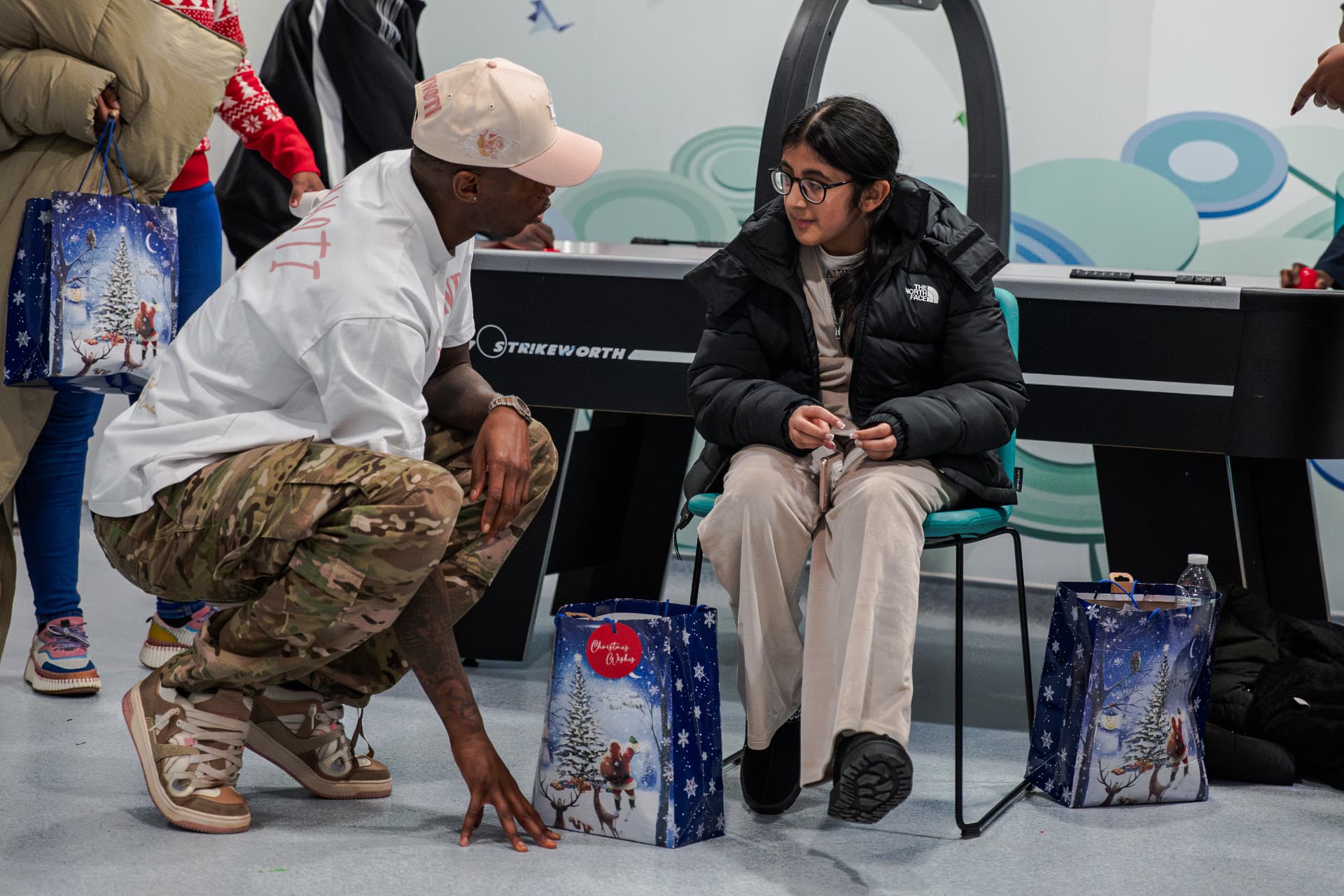 Kofi Josephs giving a Christmas present to a child at Manchester Royal Children’s Hospital