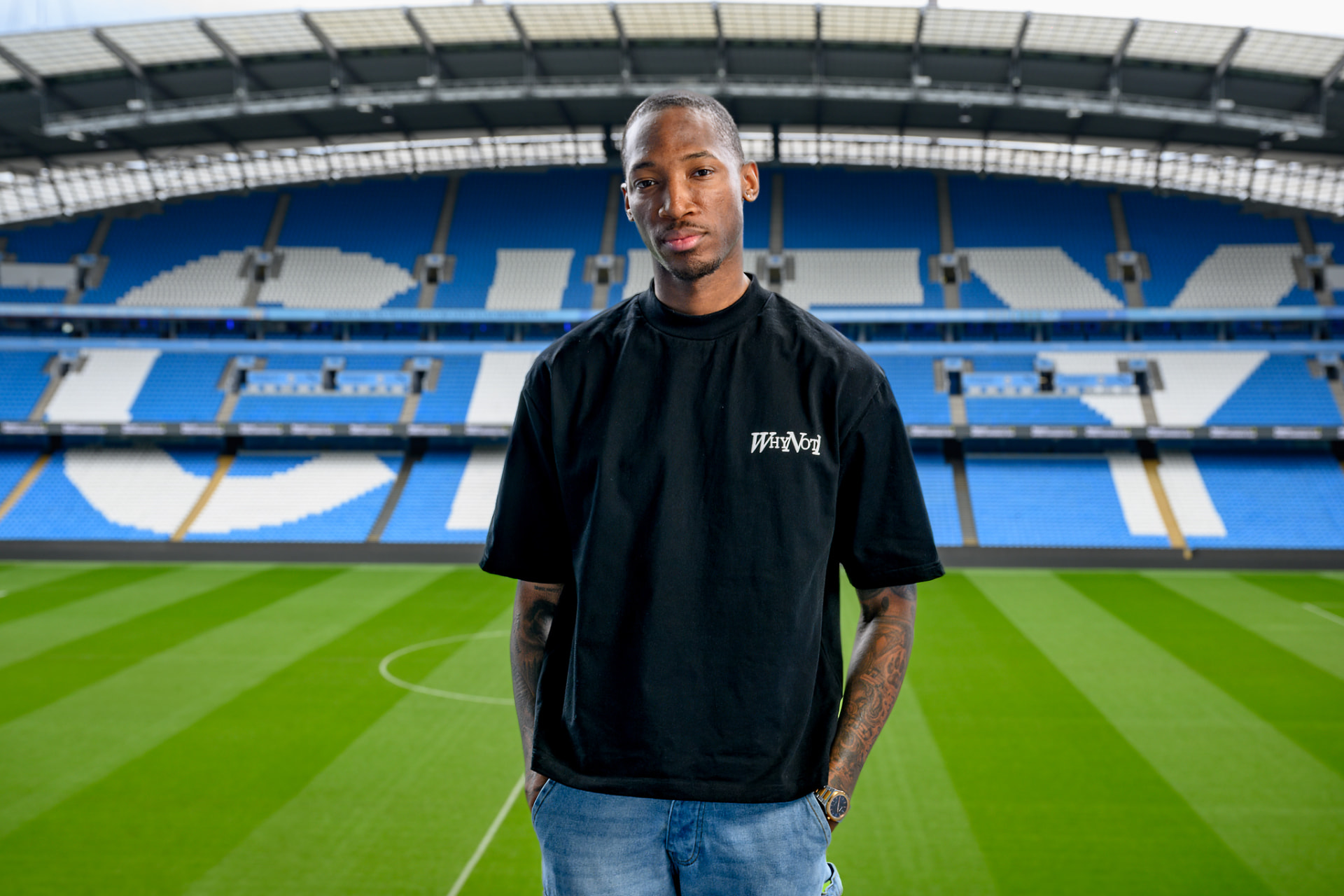 Kofi Josephs wearing a Why Not I t-shirt in a stadium